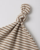 A close-up of a soft fabric baby lovey or comforter with horizontal brown and cream stripes, tied in a knot at the top against a light gray background.