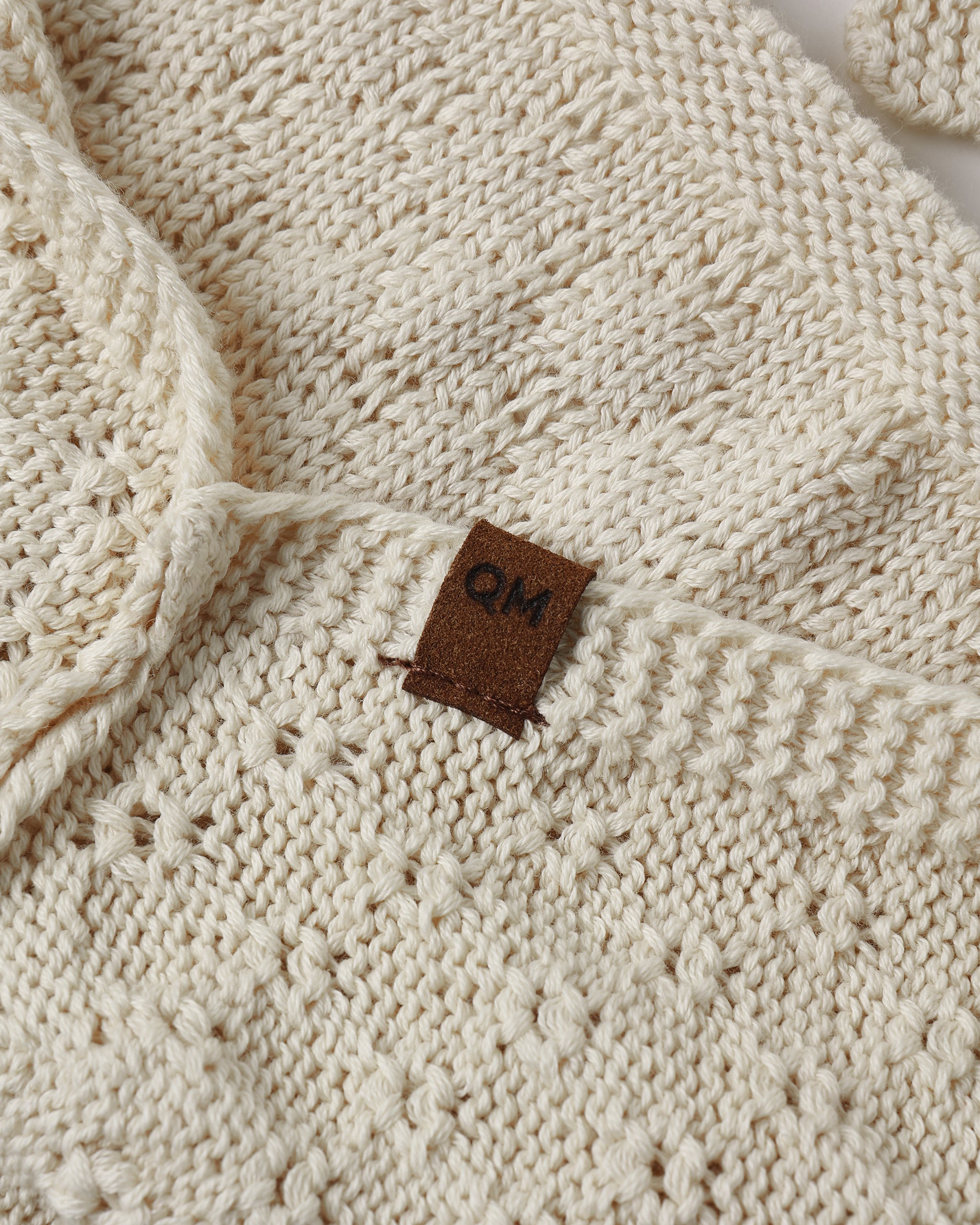 A cream-colored knit with a textured diamond pattern.