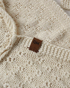A cream-colored knit with a textured diamond pattern.