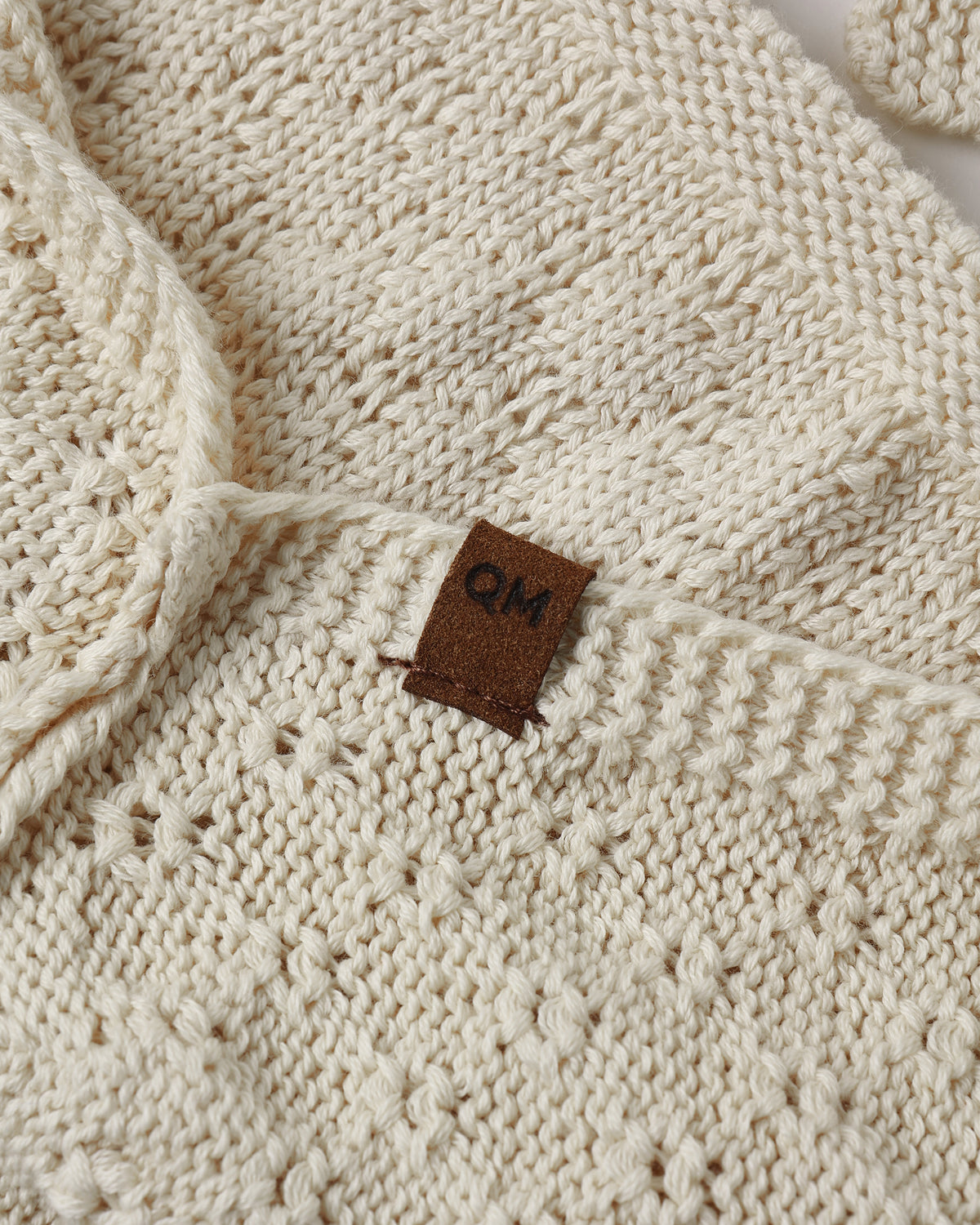 A cream-colored knit with a textured diamond pattern.