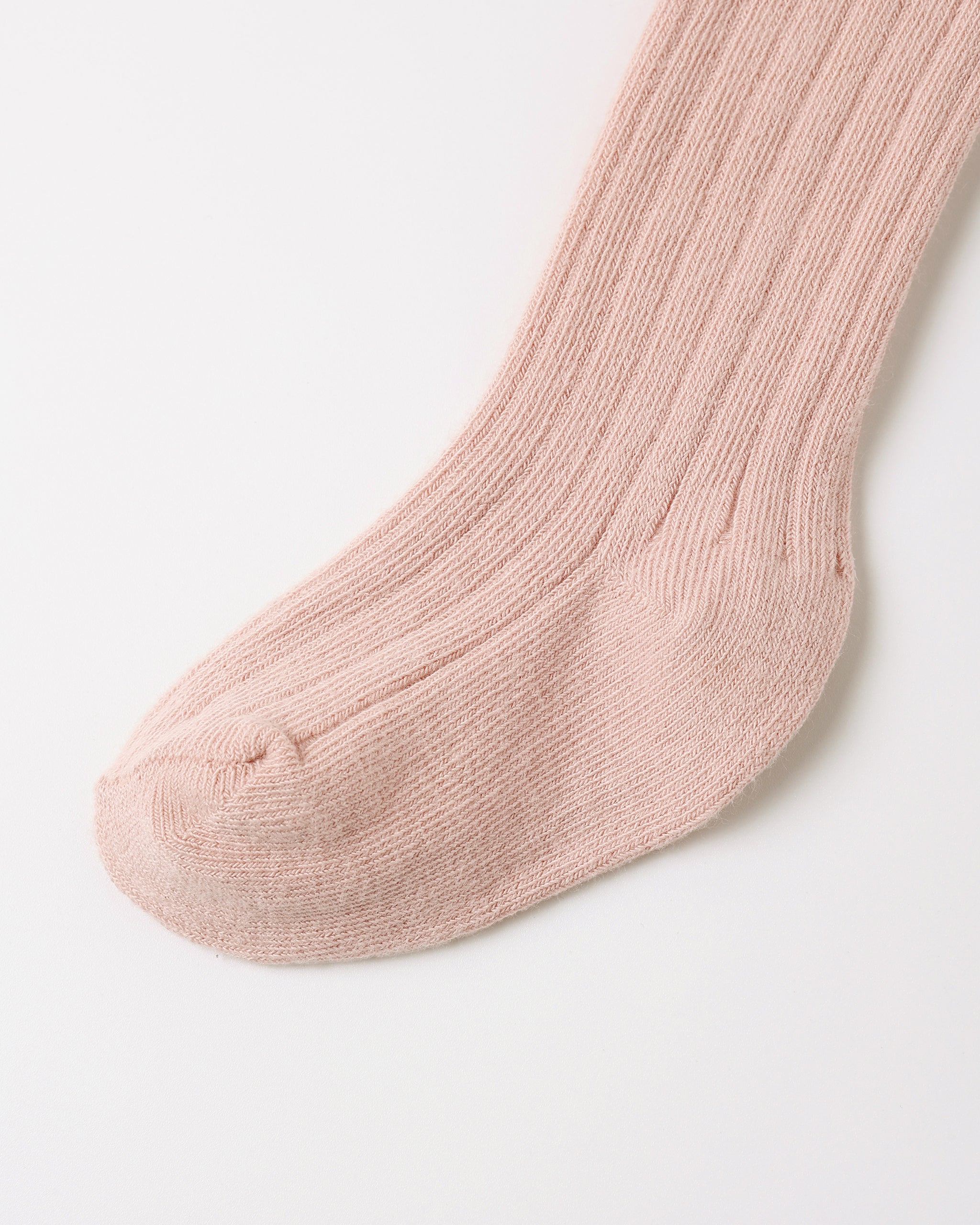A single ribbed knit sock in a soft dusty pink color, shown against a clean white background.
