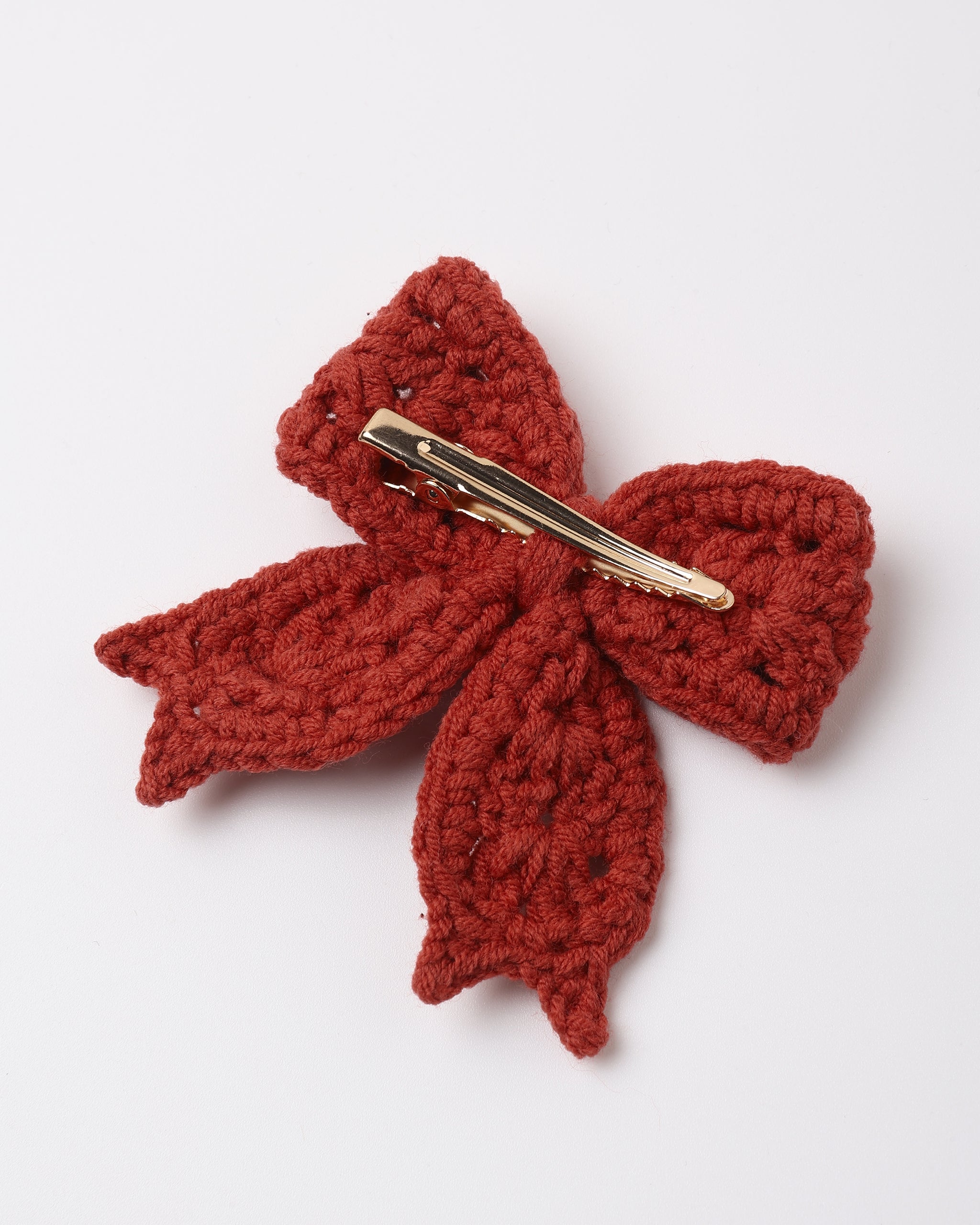 A rich, earthy redwood crochet hair bow with a textured, delicate design, attached to a gold alligator clip and shown from the back against a plain white background.