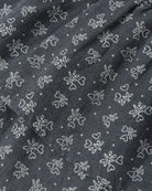 A close-up of dark gray fabric with a repeating white embroidered pattern of small flowers, hearts, and dots.