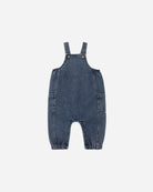 A baby's blue denim overall romper with adjustable shoulder straps and front patch pockets, shown flat on a light gray background.