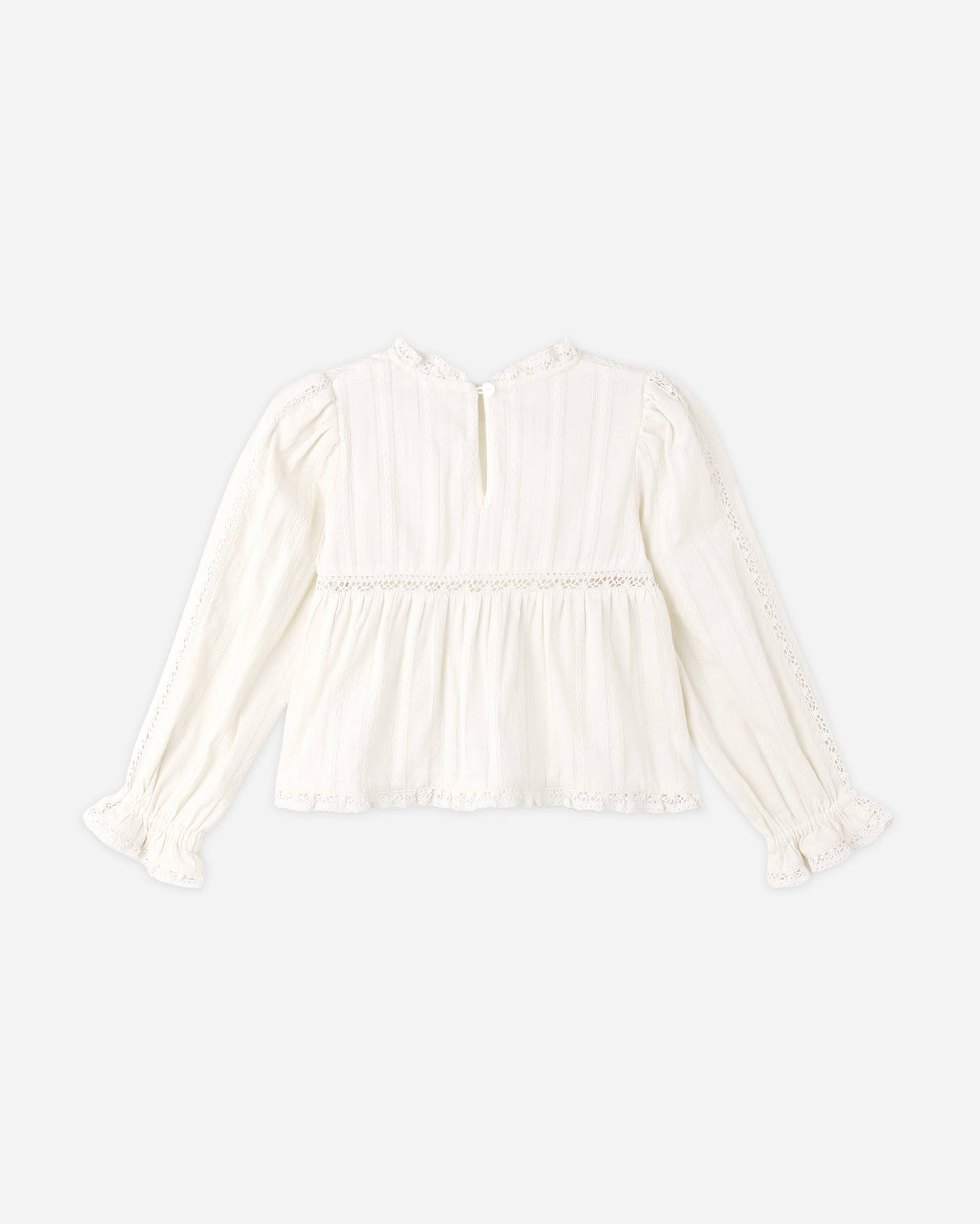 An off-white long-sleeve blouse with a ruffled high neck, vertical pleats, a gathered waist seam, and lace-trimmed cuffs, shown against a plain light gray background.