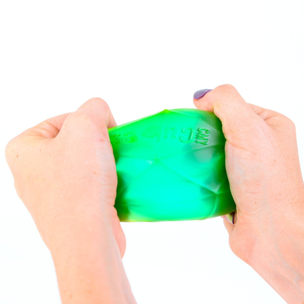 Green stress ball being held and squeezed by hands on a white background