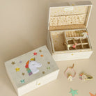 Wooden jewelry box with unicorn design on lid, open to reveal jewelry inside.