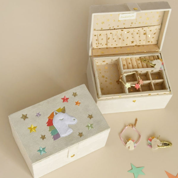 Wooden jewelry box with unicorn design on lid, open to reveal jewelry inside.