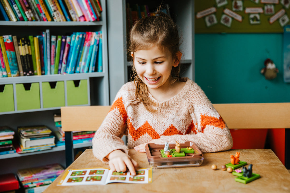 Young girl playing with toys at a table in a classroom setting