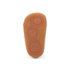 The brown rubber outsole of a baby bootie, showing embossed circular markings with the numbers 1, 2, and 3 and a small car icon, photographed on a white background.