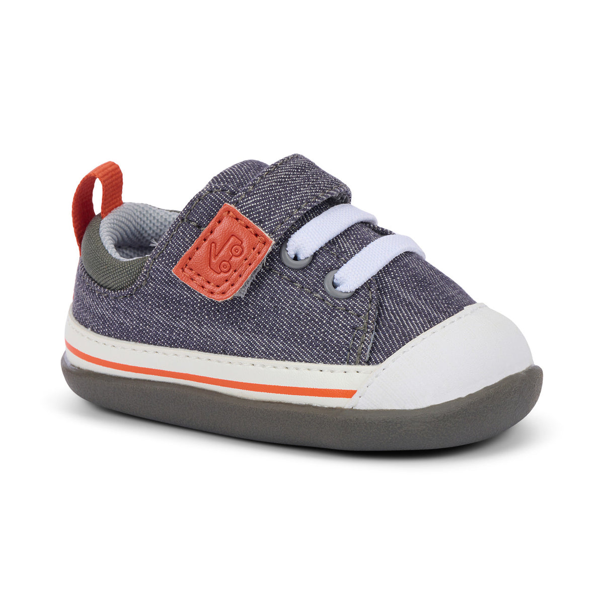 A toddler's canvas sneaker in a textured slate blue-gray color, featuring a white rubber toe cap, white hook-and-loop straps, an orange pull tab, and a thin orange stripe on the sole.