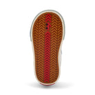 Close-up of a shoe sole with brown tread pattern and red accents on a white background