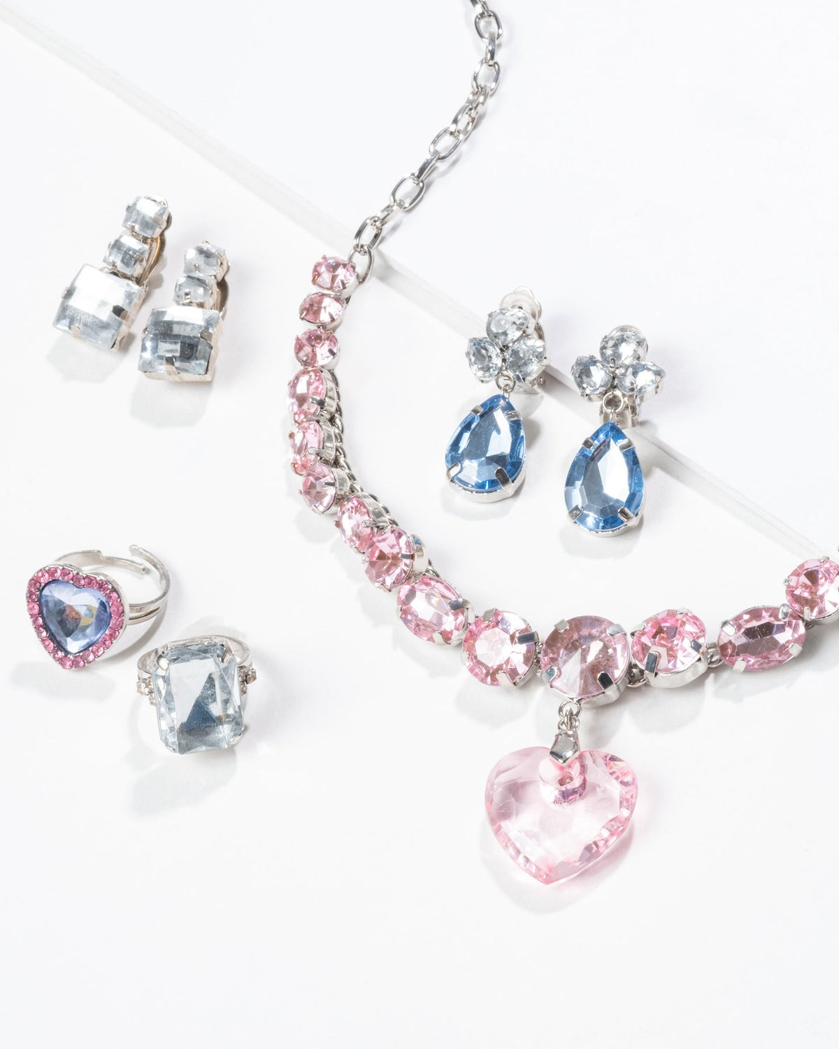 Jewelry set with pink and blue crystals on a white background