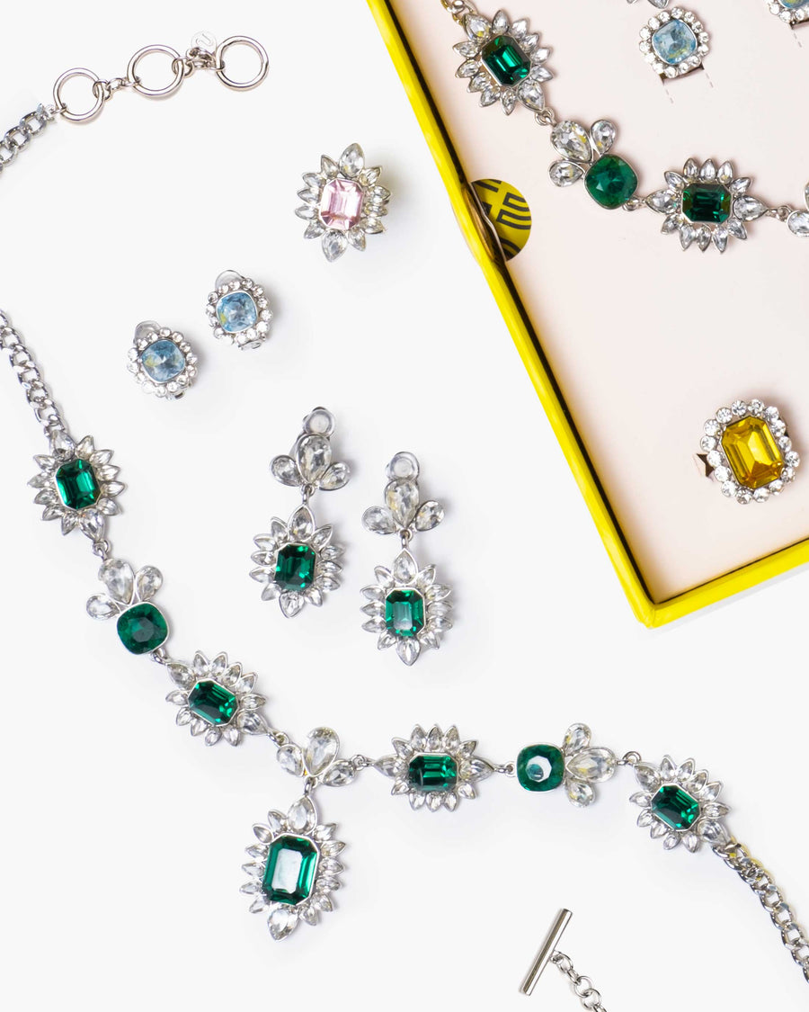 Jewelry set with green gemstones on a white background