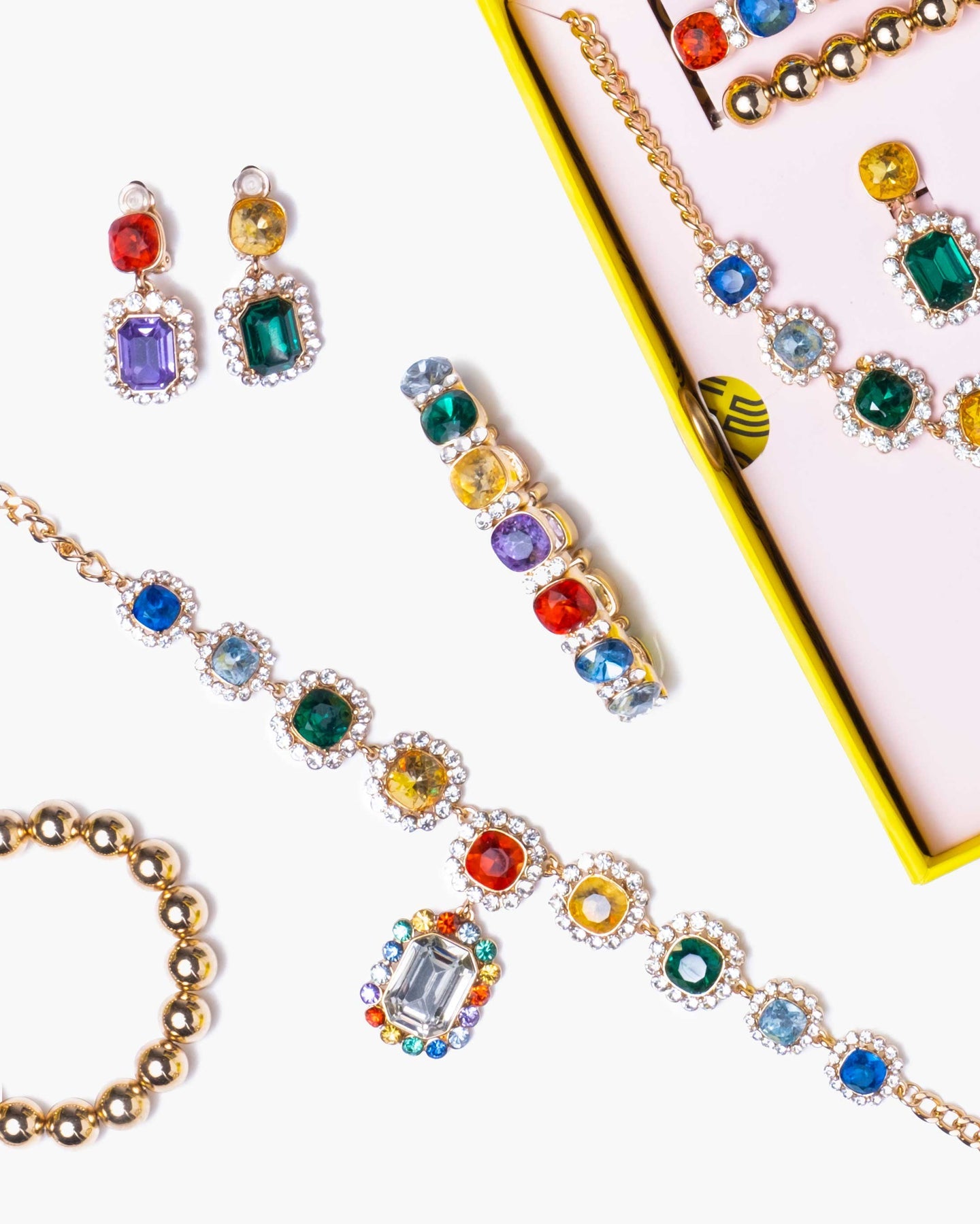 Colorful gemstone jewelry set including earrings and bracelet on a white background
