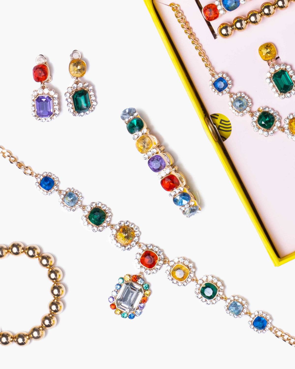 Colorful gemstone jewelry set including earrings and bracelet on a white background