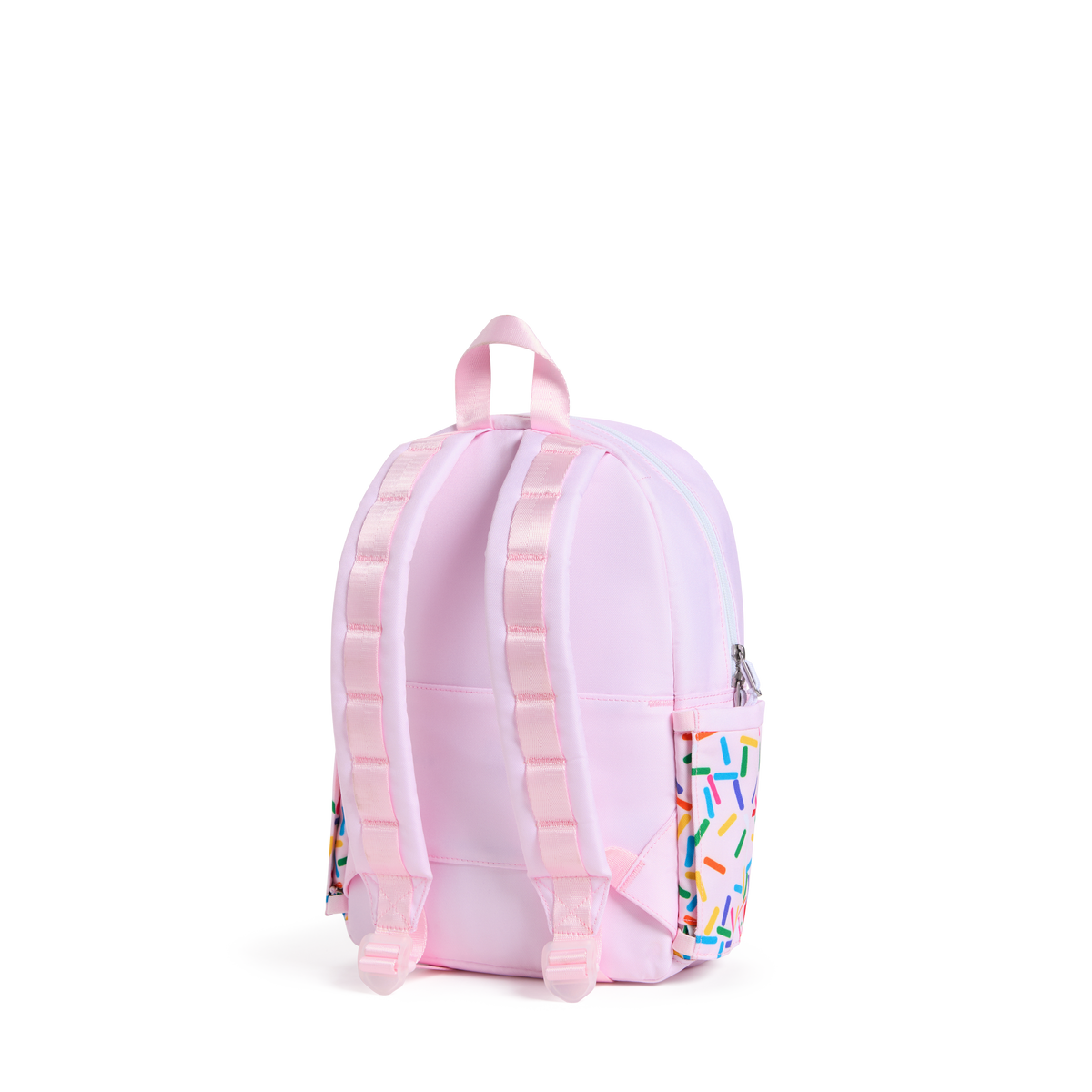 A light pink backpack shown from the back, featuring padded shoulder straps, a top carry handle, and a side pocket decorated with a colorful sprinkle pattern, set against a plain white background.