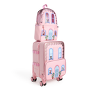A pink State Bags Mini Logan house-style backpack stacked on top of a matching pink rolling carry-on suitcase, featuring blue telescopic handles, 360-degree spinner wheels, and front graphic details including arched windows, potted plants, and a central blue front door against a transparent background.