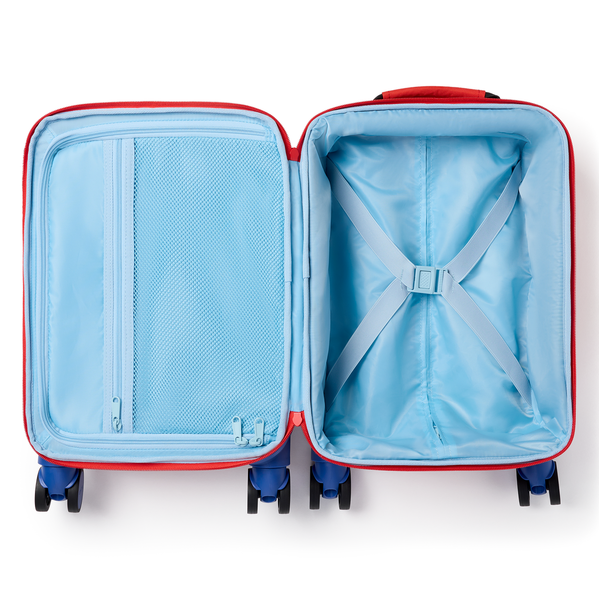 Open view of a red State Bags Mini Logan carry-on suitcase, revealing light blue interior lining with elastic compression straps and a zippered mesh compartment, set against a transparent background.