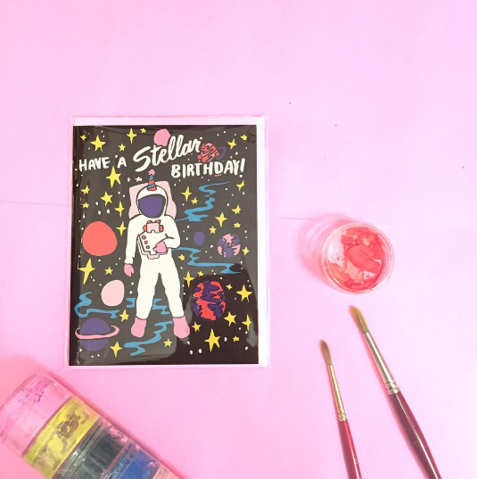 Greeting card with astronaut design and 'Have a Stellar Birthday!' text on a pink background.