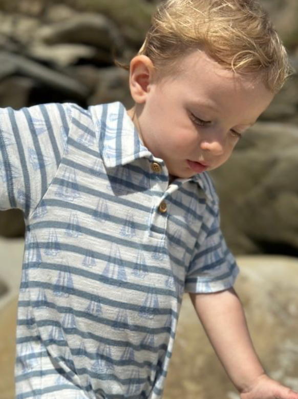 Child wearing a blue and white striped shirt outdoors