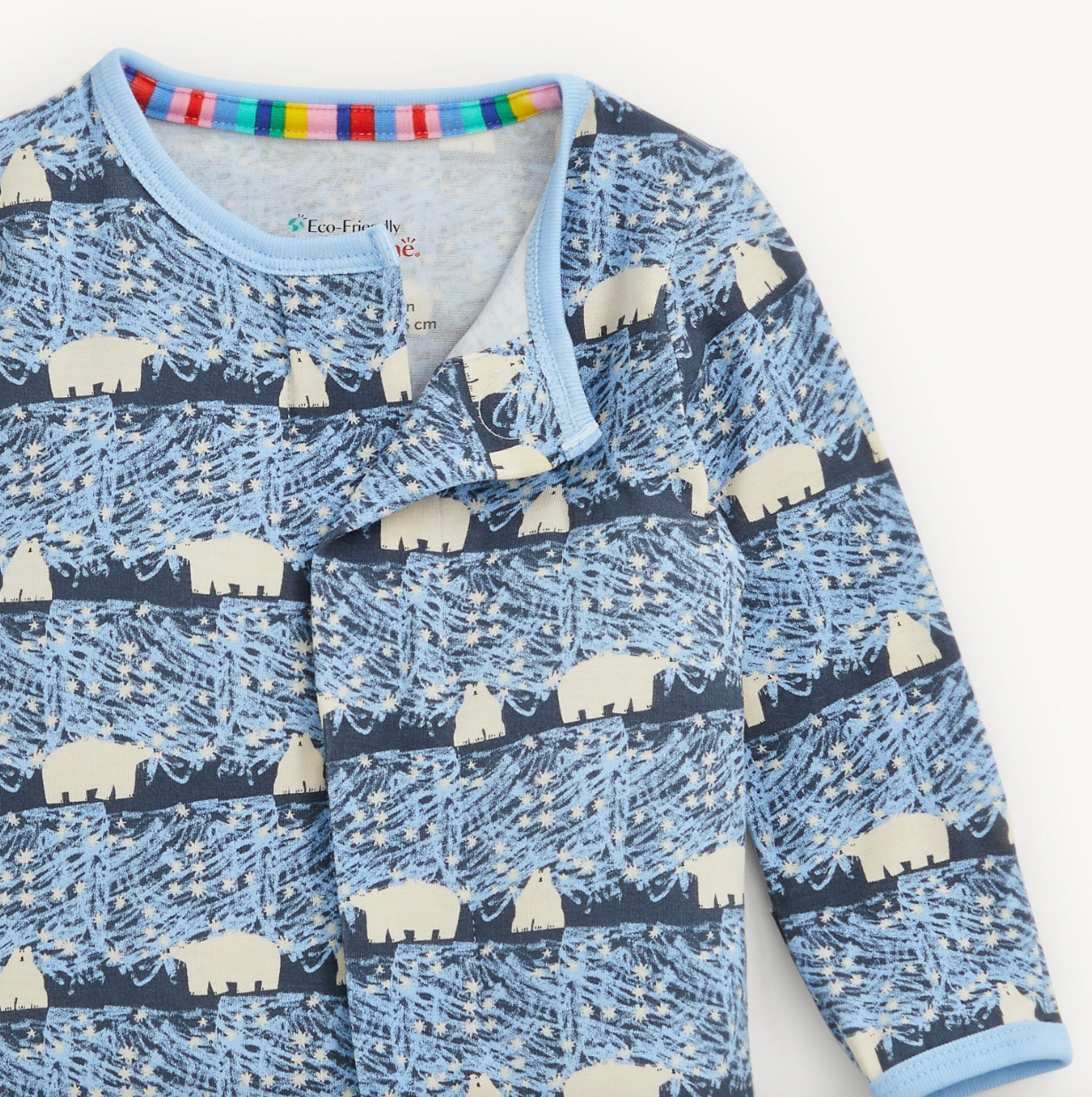 A close-up of a baby long-sleeve top with a blue and navy print featuring cream polar bears and abstract line patterns, with a light blue collar and cuffs.