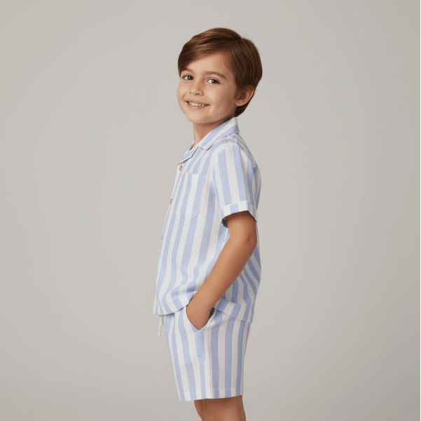 Child wearing a blue and white striped outfit on a gray background