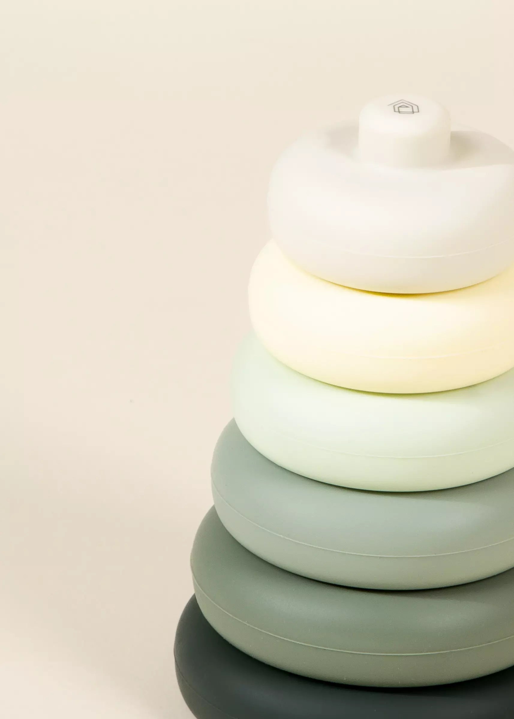 Stack of colorful round objects on a light beige background