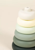 Stack of colorful round objects on a light beige background