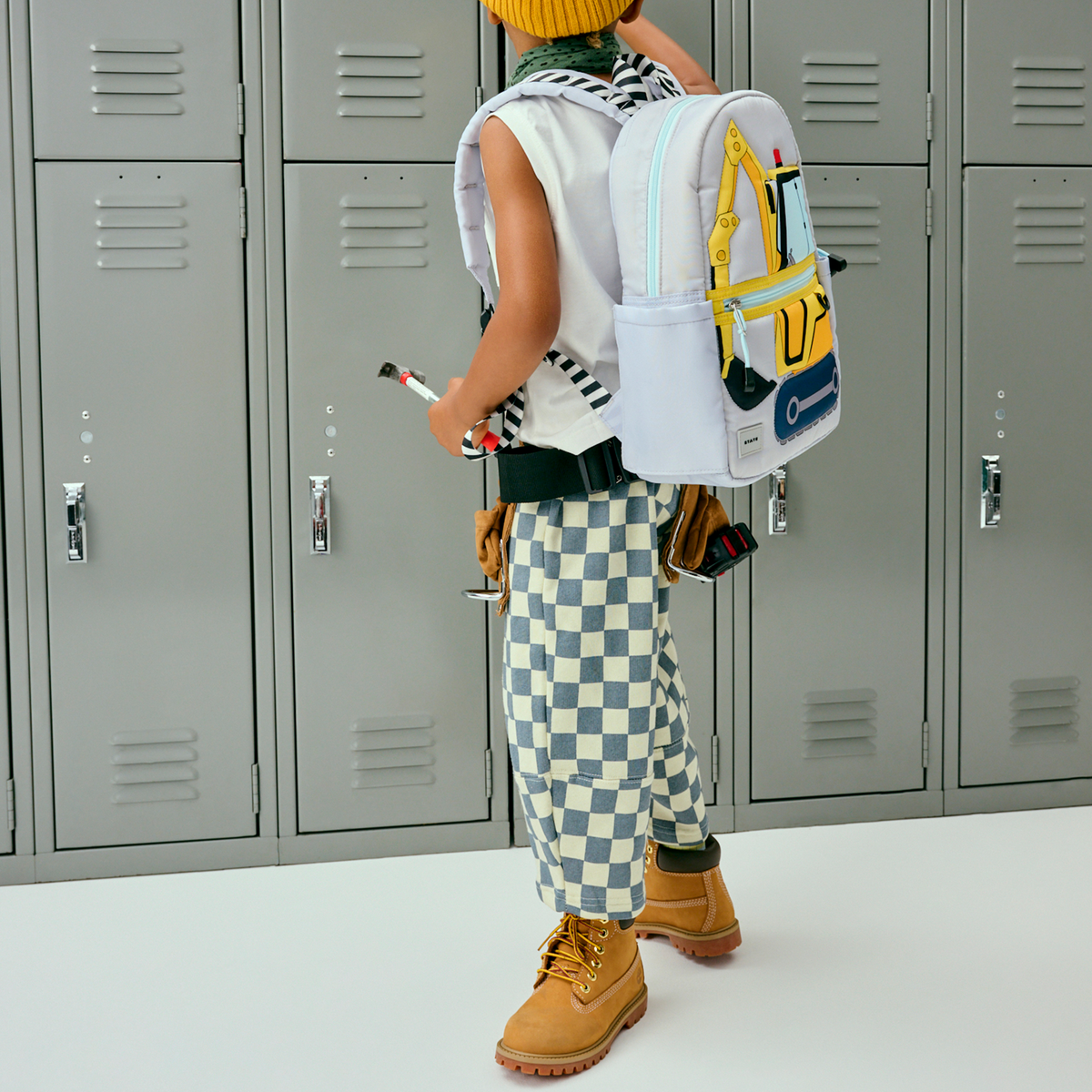 Person wearing a colorful backpack in front of gray lockers