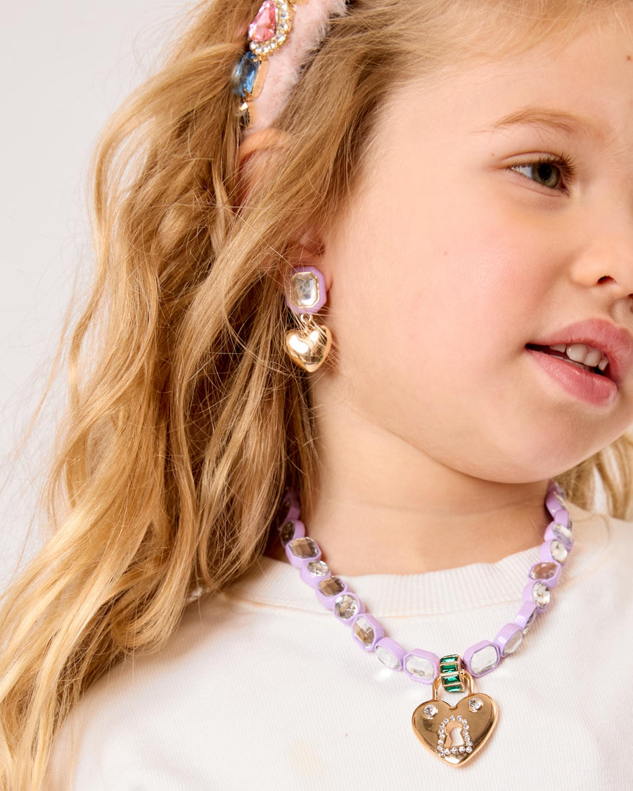 Close-up of a young girl wearing colorful jewelry including earrings and a necklace.