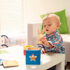 Child playing with a wooden toy in a bright room