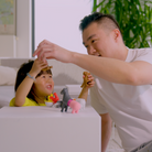 Man and child playing with toys on a bed
