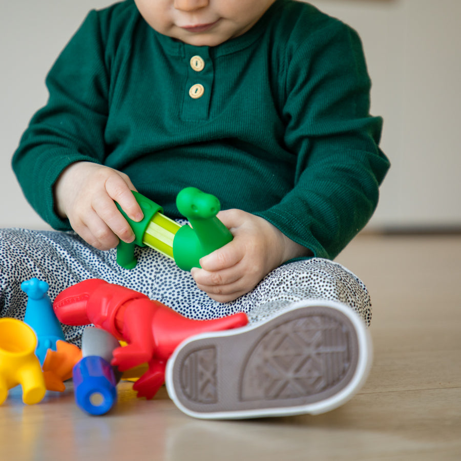 Child playing with colorful toys on a wooden floor