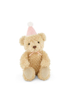 Plush teddy bear wearing a pink party hat on a white background