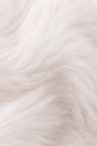 A close-up view of ultra-soft, fluffy white plush fur, highlighting its dense and textured feel.