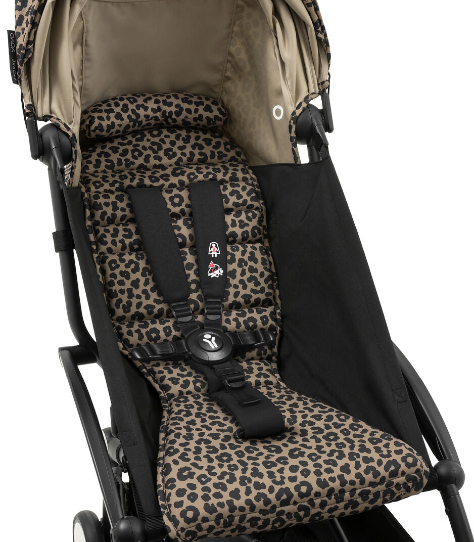 Leopard print baby seat cover with black straps on a stroller