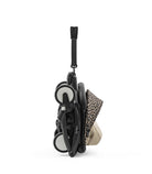Foldable baby stroller with leopard print cover on a white background