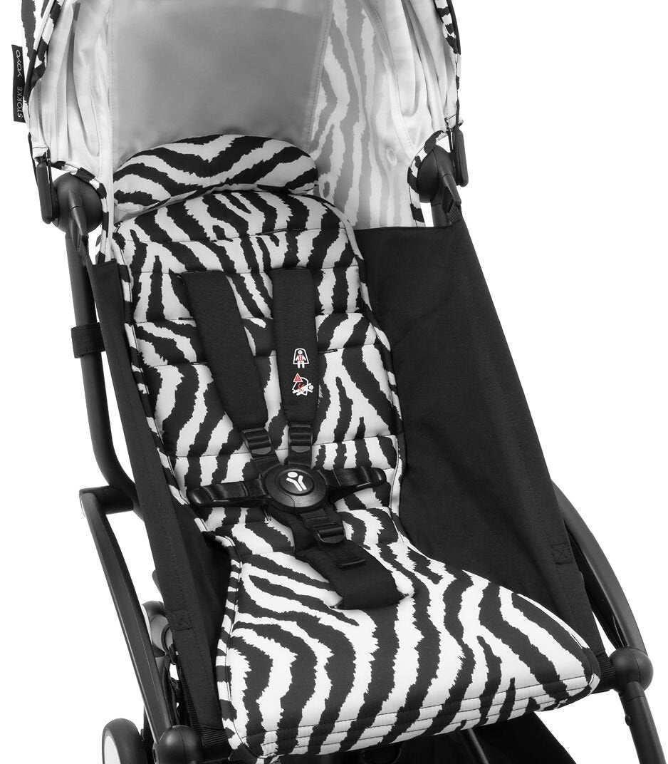 Baby stroller with zebra patterned seat cover on a white background