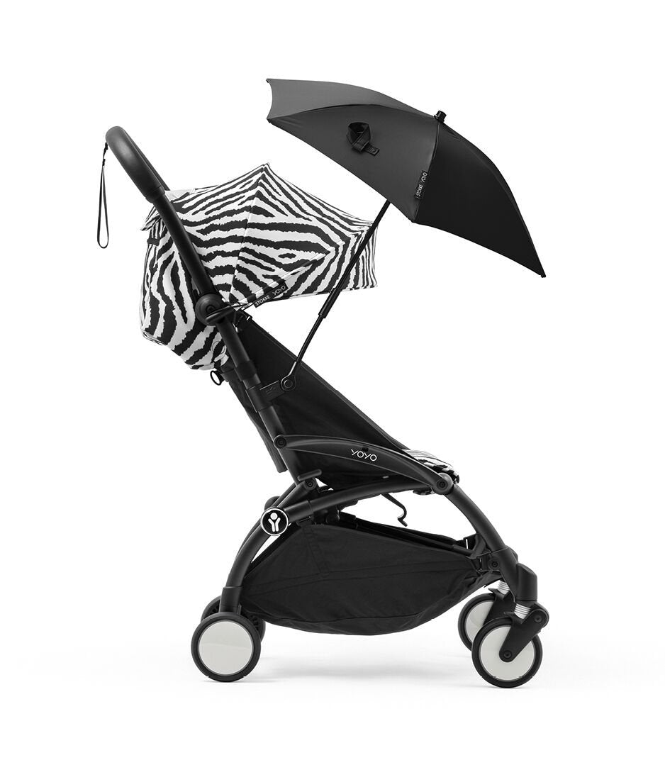 Black stroller with a zebra-patterned sunshade and black umbrella on a white background
