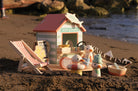 Toy beach hut with deck chair and figures on a sandy beach