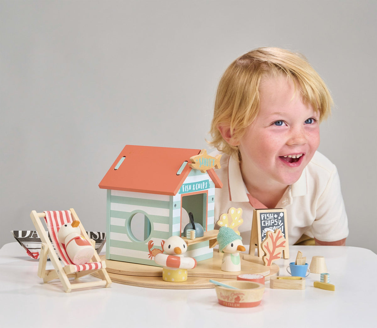 Child playing with a wooden toy set on a table