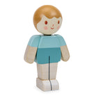 Wooden toy figure of a boy with a blue shirt and beige pants on a white background