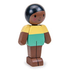Wooden toy figure with a black hair bun, yellow shirt, green shorts, and brown shoes on a white background.