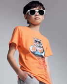 Child wearing an orange t-shirt with a tiger graphic and sunglasses on a gray background