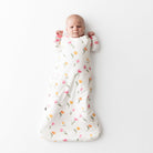 Baby wrapped in a floral-patterned swaddle on a white background