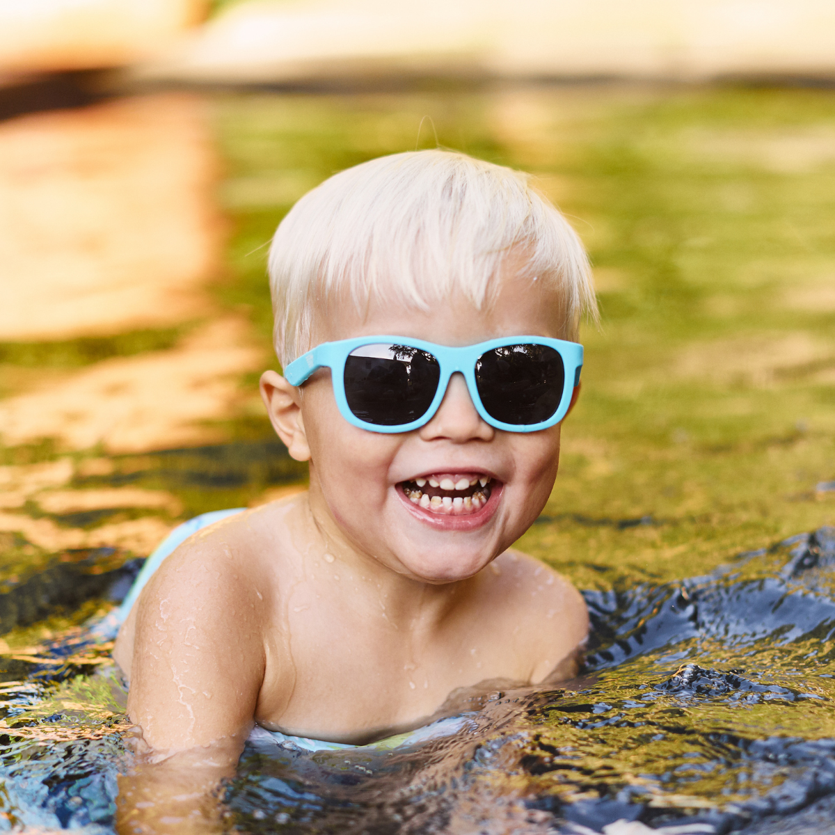 Child wearing blue sunglasses in a pool