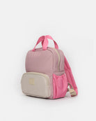 A small pink and beige backpack with dual top handles, a front zippered pocket, and a side mesh pocket, shown on a plain light gray background.