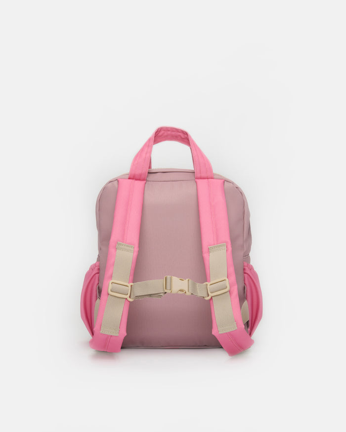 A pink backpack shown from the back, featuring bright pink shoulder straps with beige adjustable buckles and a matching pink top handle, set against a plain light gray background.