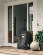 Black storm door cover on a front porch with a house in the background